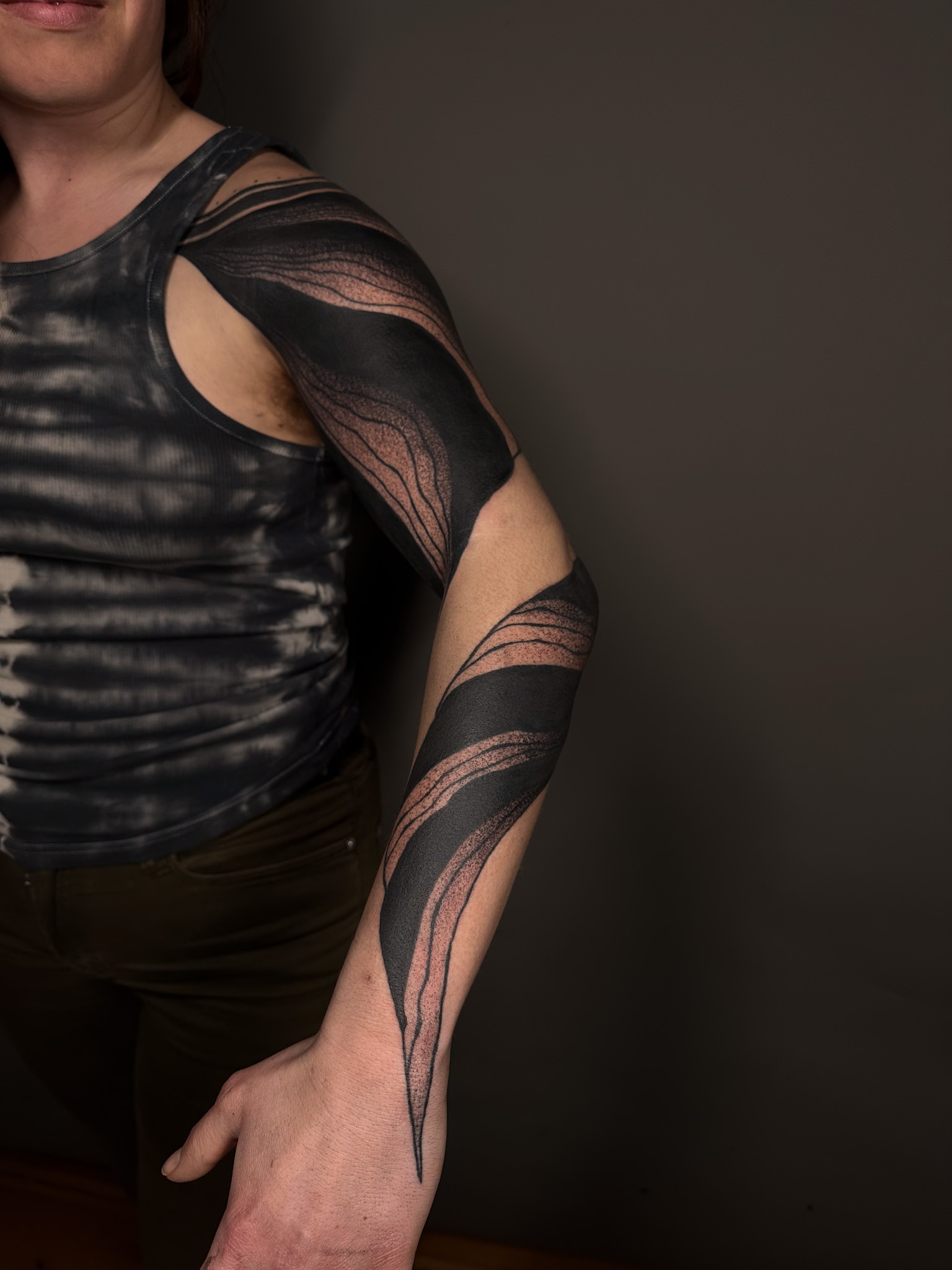 Heavy blackwork bands sweeping over the shoulder and down the arm