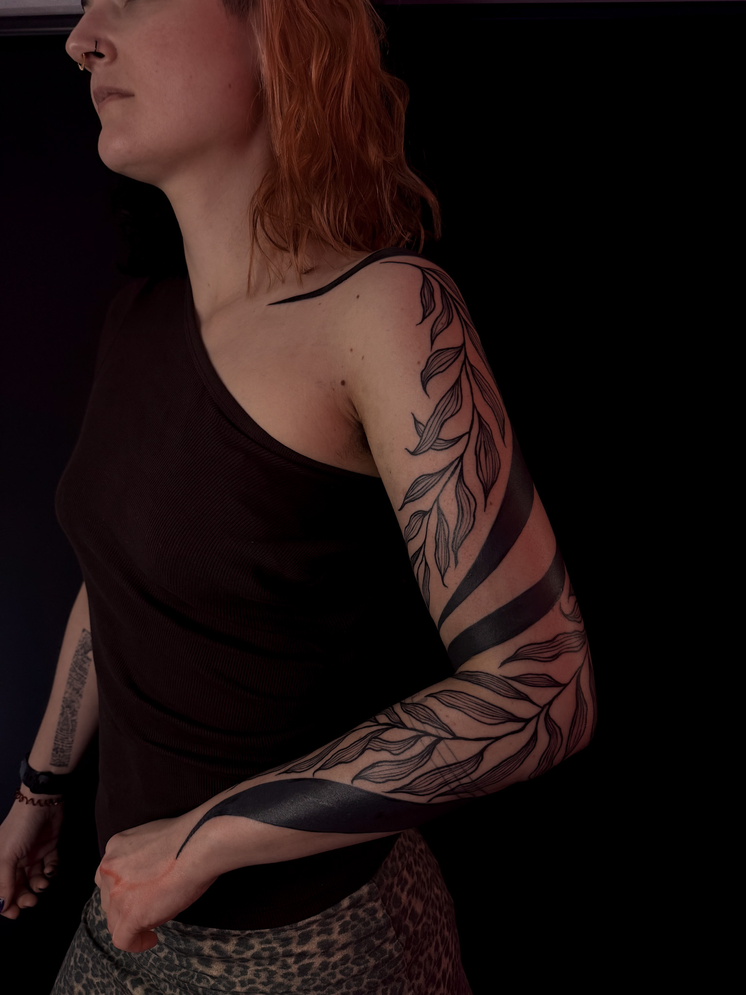 Fine-line leaves climbing the arm, bound by black bands